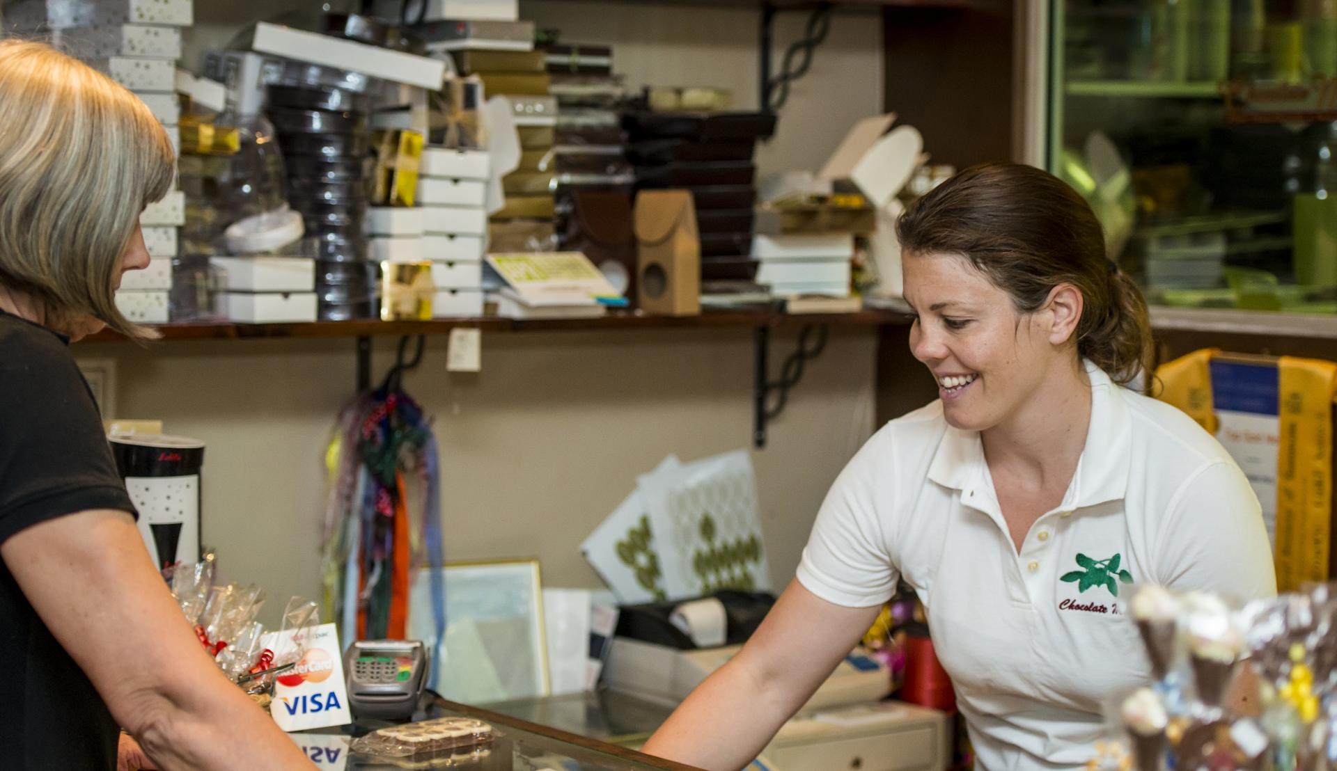 lady serving customer is a small chocolate shop