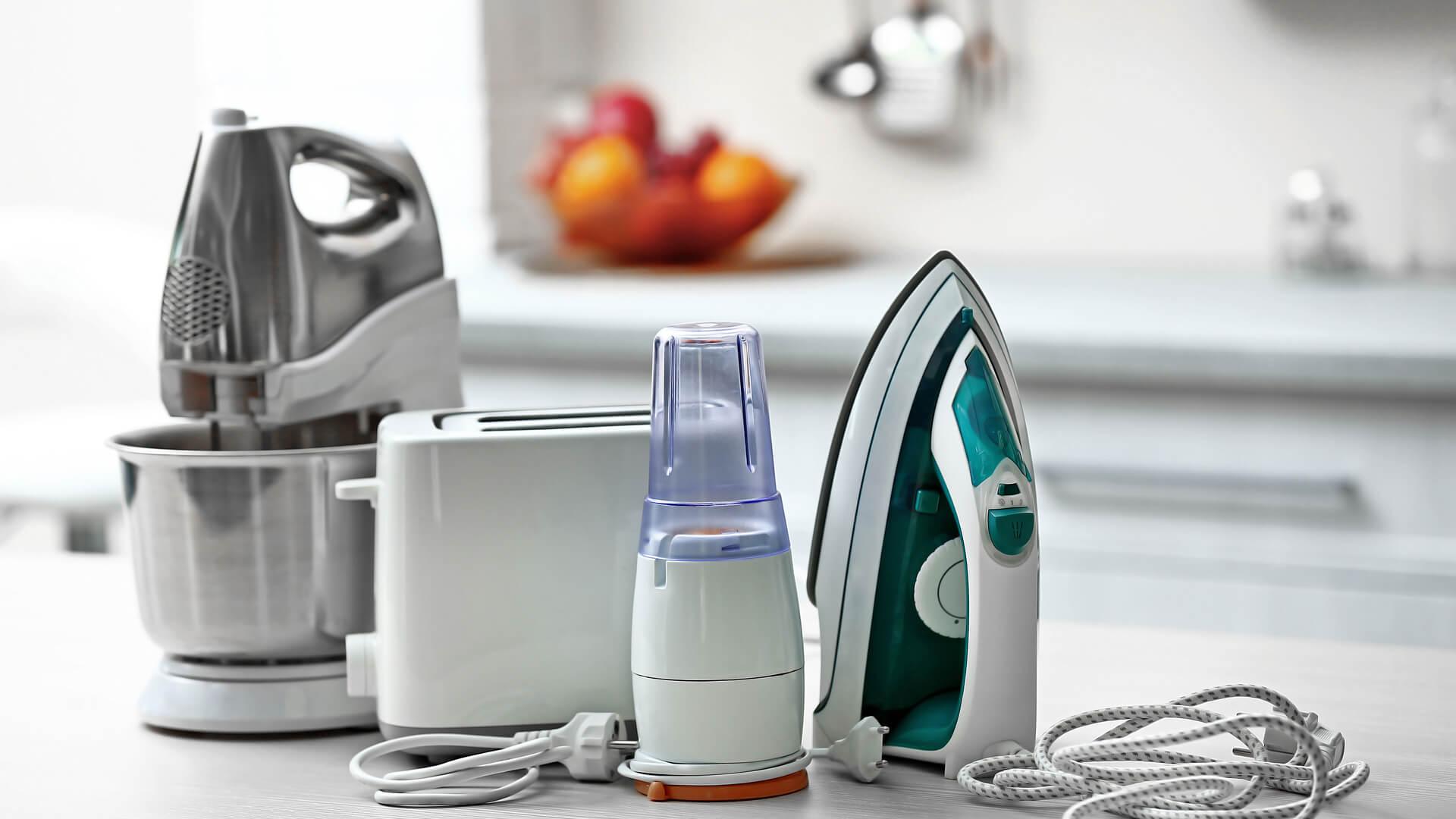 toaster, mixer, blender and iron sitting on white kitchen bench