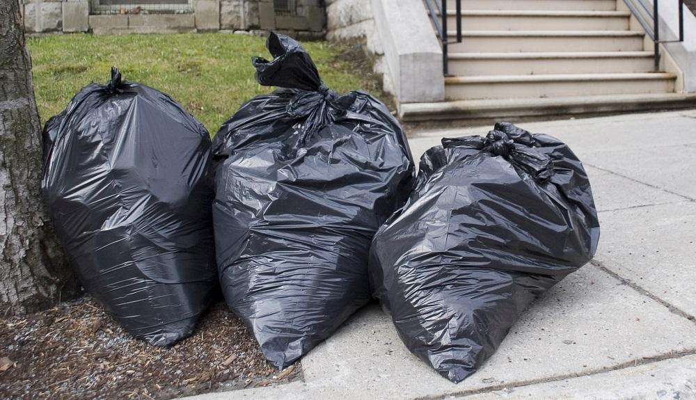 garbage bags sitting on footpath