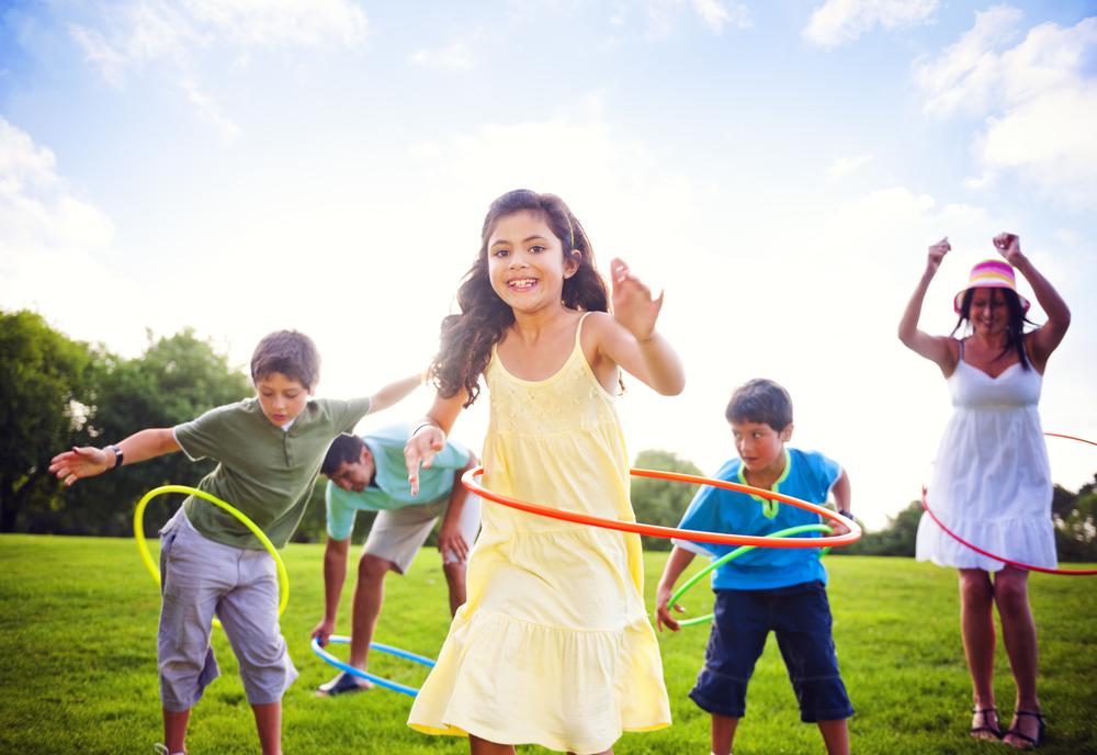 children hula hooping in field