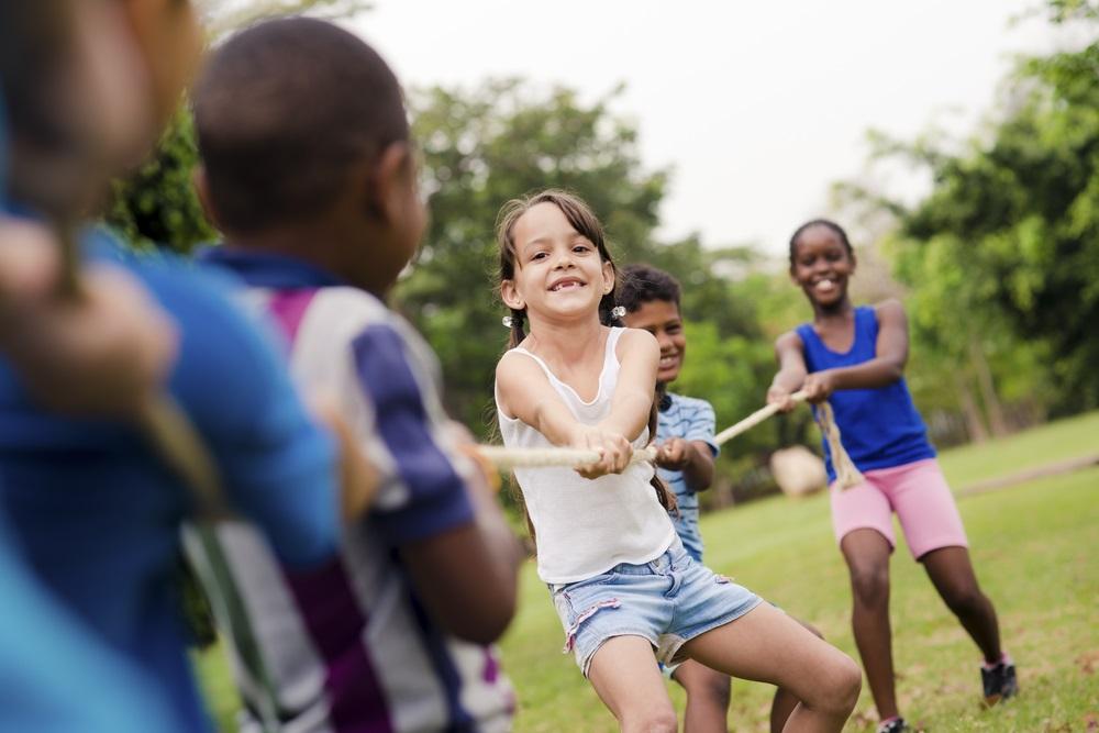 children playing tug of war in park