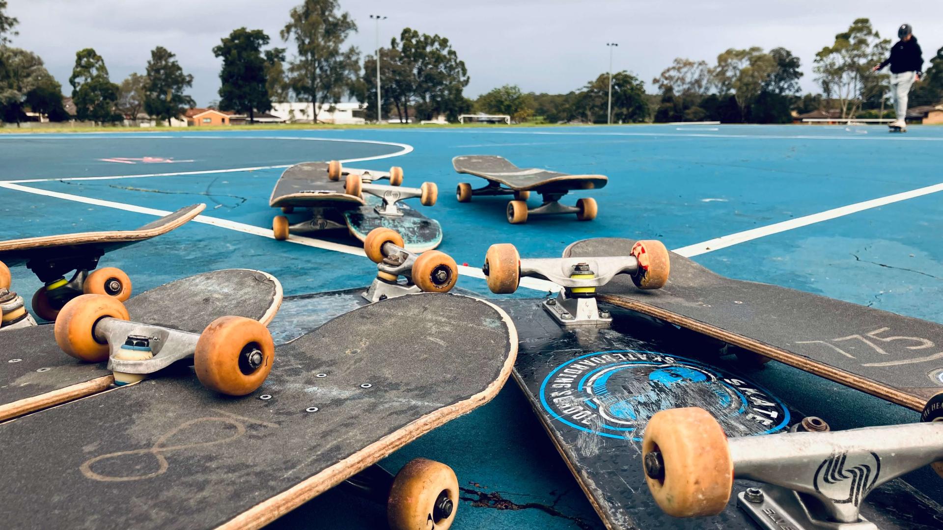 Skateboards scattered on a netball court after a skating program